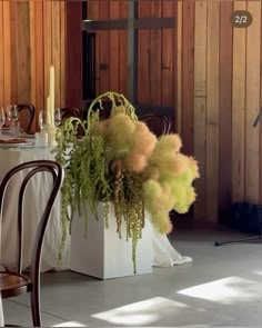 the table is set with white linens and flowers in vases, along with candles