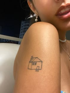 a woman with a small house tattoo on her arm