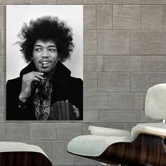 a black and white photo of a man with an afro hairstyle, in front of a brick wall