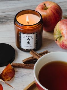 an apple and cinnamon stick next to a cup of tea