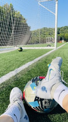 a person laying on the ground next to a soccer ball