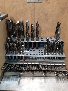 a bunch of drilling tools sitting on top of a metal tray in a room