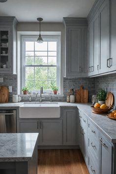 a kitchen filled with lots of gray cabinets and counter top space next to a window