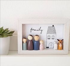 a family photo frame sitting on top of a shelf next to a potted plant