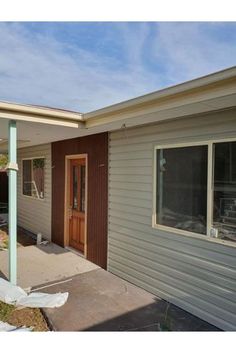 a house that is under construction with the front door and side porch missing some siding