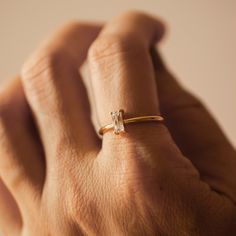 a woman's hand with a diamond ring on it