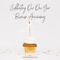 a cupcake with a sparkler on it and the words celebrating our one year business anniversary