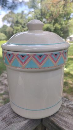 a white ceramic container sitting on top of a wooden table