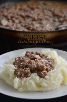 a white plate topped with mashed potatoes covered in ground beef and gravy