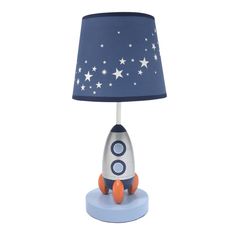 a lamp with a blue shade on it and a rocket ship sitting on the base