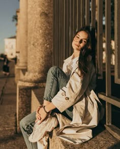 a woman sitting on the side of a building