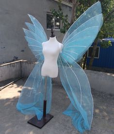 a mannequin dressed as a blue fairy tale butterfly, with wings spread out