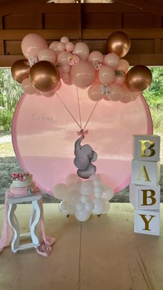 a baby shower is set up with balloons and an elephant on the top of it