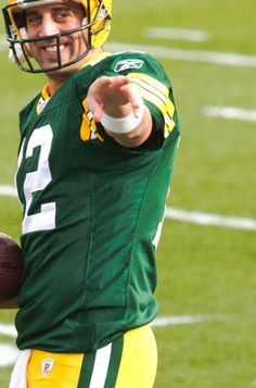 a man in green and yellow uniform holding a football