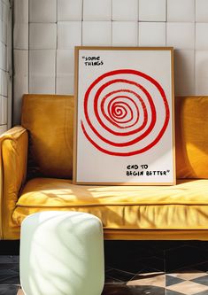 a red and white poster sitting on top of a yellow couch