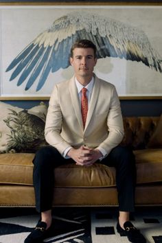 a man in a suit sitting on a couch