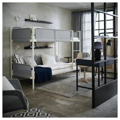 a bedroom with bunk beds and desks in it