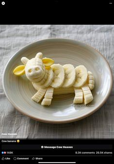 a white plate topped with sliced bananas and a cut up animal made out of banana slices