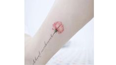 a woman's arm with a pink flower on it and the word love written in cursive writing