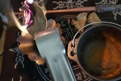 an old frying pan is sitting on a table next to a candle and spoon