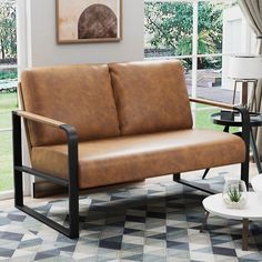 a living room with a brown leather couch and coffee table in front of a window