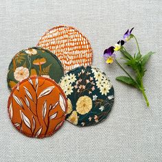 four coasters with different designs and flowers on them