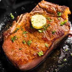 a piece of steak is being cooked in a skillet with parsley on top