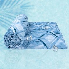 a blue blanket sitting on top of a swimming pool next to a diamond shaped object