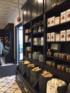 a man standing in front of a store filled with lots of jars and food items