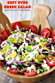 a salad in a wooden bowl with tomatoes, onions and feta cheese on top