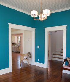 an empty living room with blue walls and wood flooring is seen in this image