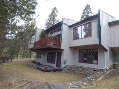 a two story house in the woods on a cloudy day