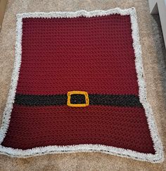 a crocheted blanket with a santa hat on it sitting on the floor next to a door