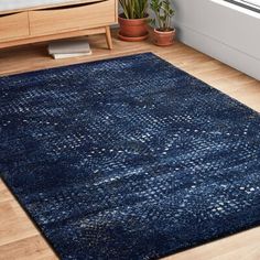 a blue area rug in a room with wooden floors