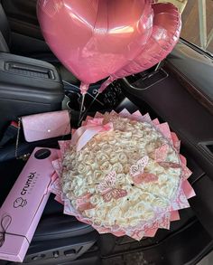 pink and white flowers in the back seat of a car with heart shaped balloons attached to it