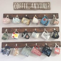 coffee mugs are hanging on a wooden rack