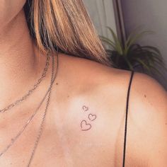 a woman's chest with two small hearts on her left side, and the word love written across the chest