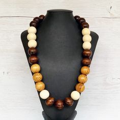 This colorful wood bead necklace was hand beaded using a mix of large 25mm round dark brown, tan, and beige wooden beads in a modern color block design. The necklace measures approximately 28 inches in length and is fastened with a silver clasp. The end result is a cool bohemian piece that fits in perfectly with almost any outfit!  Perfect for any gender.  Length can be adjusted if needed - just ask! Wood represents a sense of earthiness, spirituality, creativity, liberty, prosperity, health, an Adjustable Brown Beaded Necklace, Adjustable Brown Beaded Round Necklace, Adjustable Brown Round Beaded Necklace, Adjustable Round Brown Beaded Necklace, Rustic Brown Wooden Beaded Necklaces, Rustic Brown Wooden Bead Necklaces, Rustic Brown Wooden Beads Necklace, Brown Wooden Beaded Jewelry, Rustic Brown Necklace With Large Beads