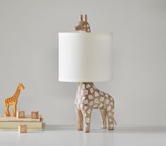 a giraffe lamp sitting next to a stack of books