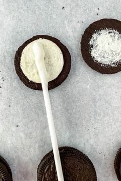 an oreo cookie being spread with white sugar on top and cookies next to it