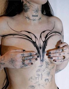 a woman with tattoos and piercings on her chest