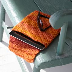 an orange purse sitting on top of a wooden bench