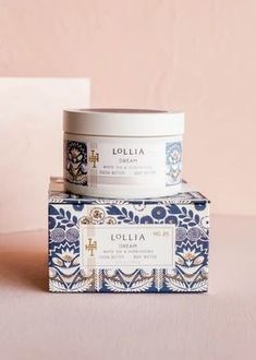 two containers of lollia cream sitting on top of each other in front of a pink wall