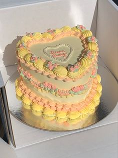 a heart shaped cake sitting on top of a white table next to a cardboard box