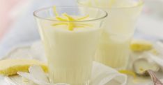 two glasses filled with lemonade sitting on top of a white plate