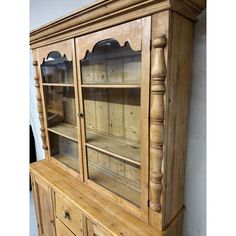 an old wooden china cabinet with glass doors