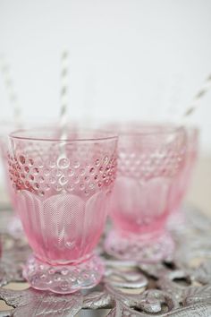 three pink glasses sitting on top of a table