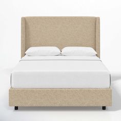 an upholstered bed with white linens and pillows on it, against a wall