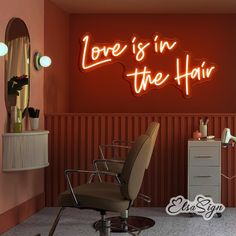 a chair in a room with a neon sign above it that says love is in the hair