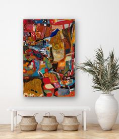 an abstract painting on the wall next to some potted plants